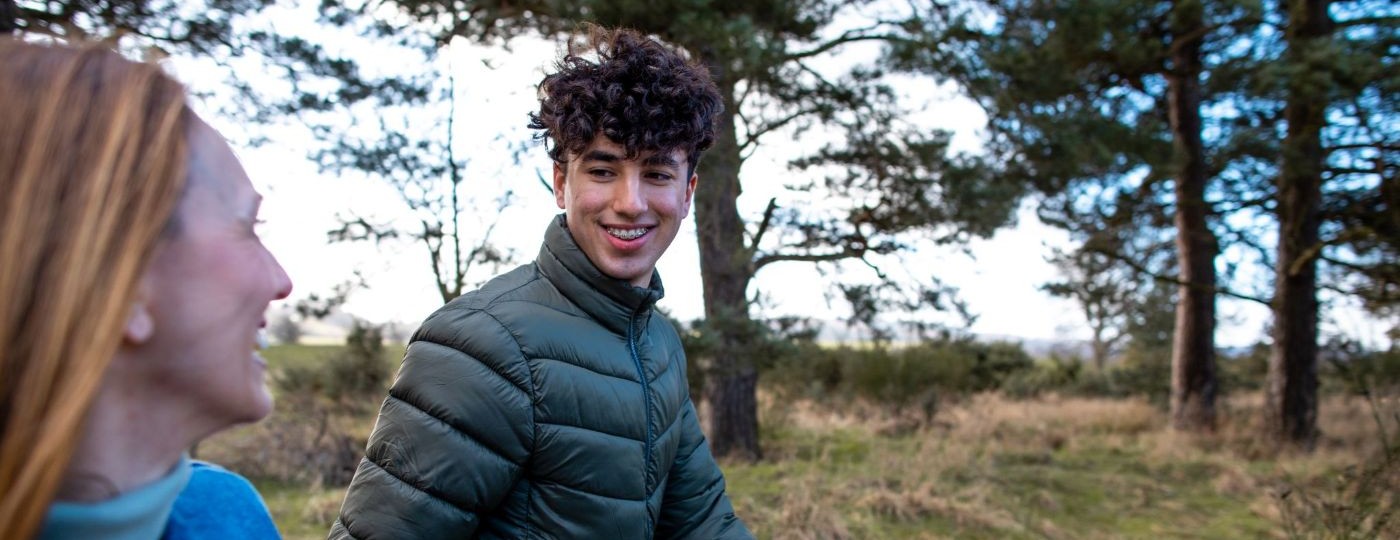 a carer and a refugee child enjoying a walk in the countryside
