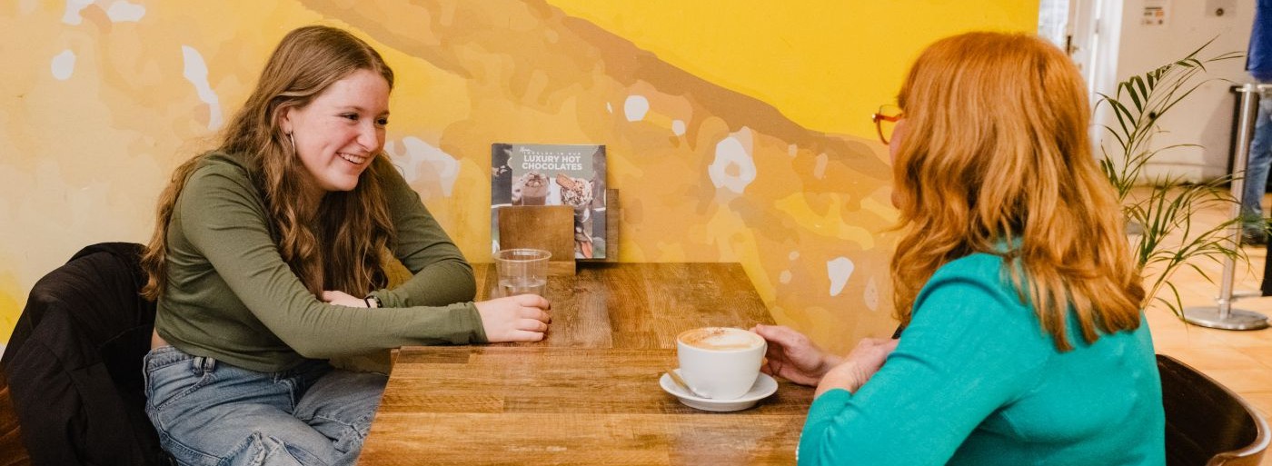 young person having coffee with an adult