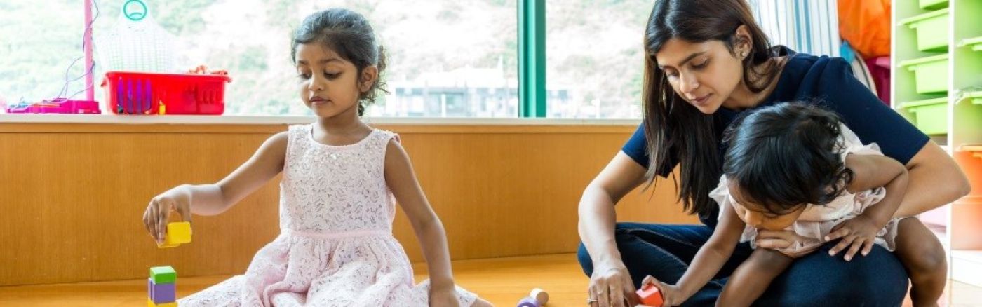 carer and children playing with blocks